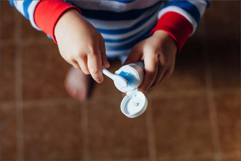 child-getting-toothpaste-on-brush.jpg